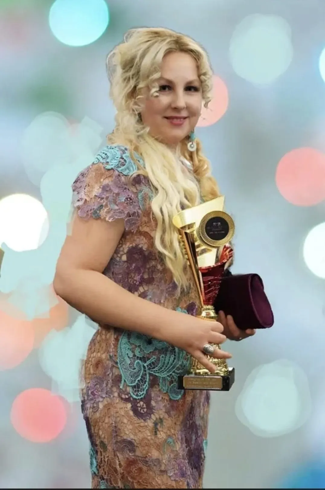 Mihaela Panaitescu holding one of her fashion design awards